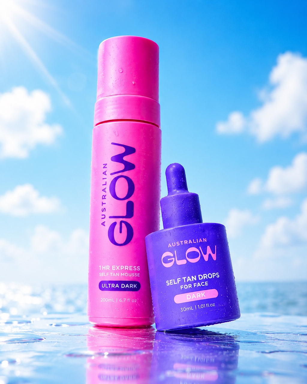 The It Couple leaning together — Ultra Dark mousse and Face Tan Drops over the ocean