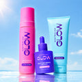 The Glow Up contents against a summer sky — Ultra Dark Express Mousse, Face Tan Drops and Gradual Tanning Moisturiser